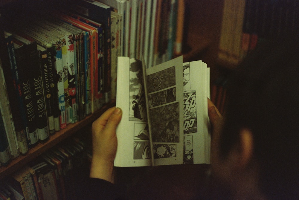 Persona sosteniendo un libro blanco y negro