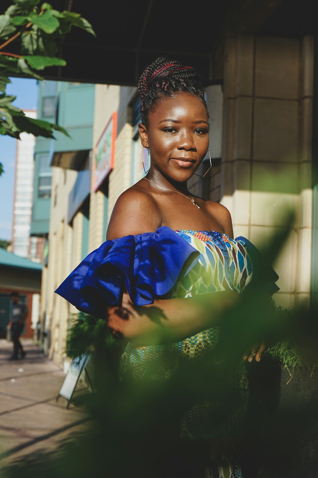 woman in green and blue tube dress holding blue textile