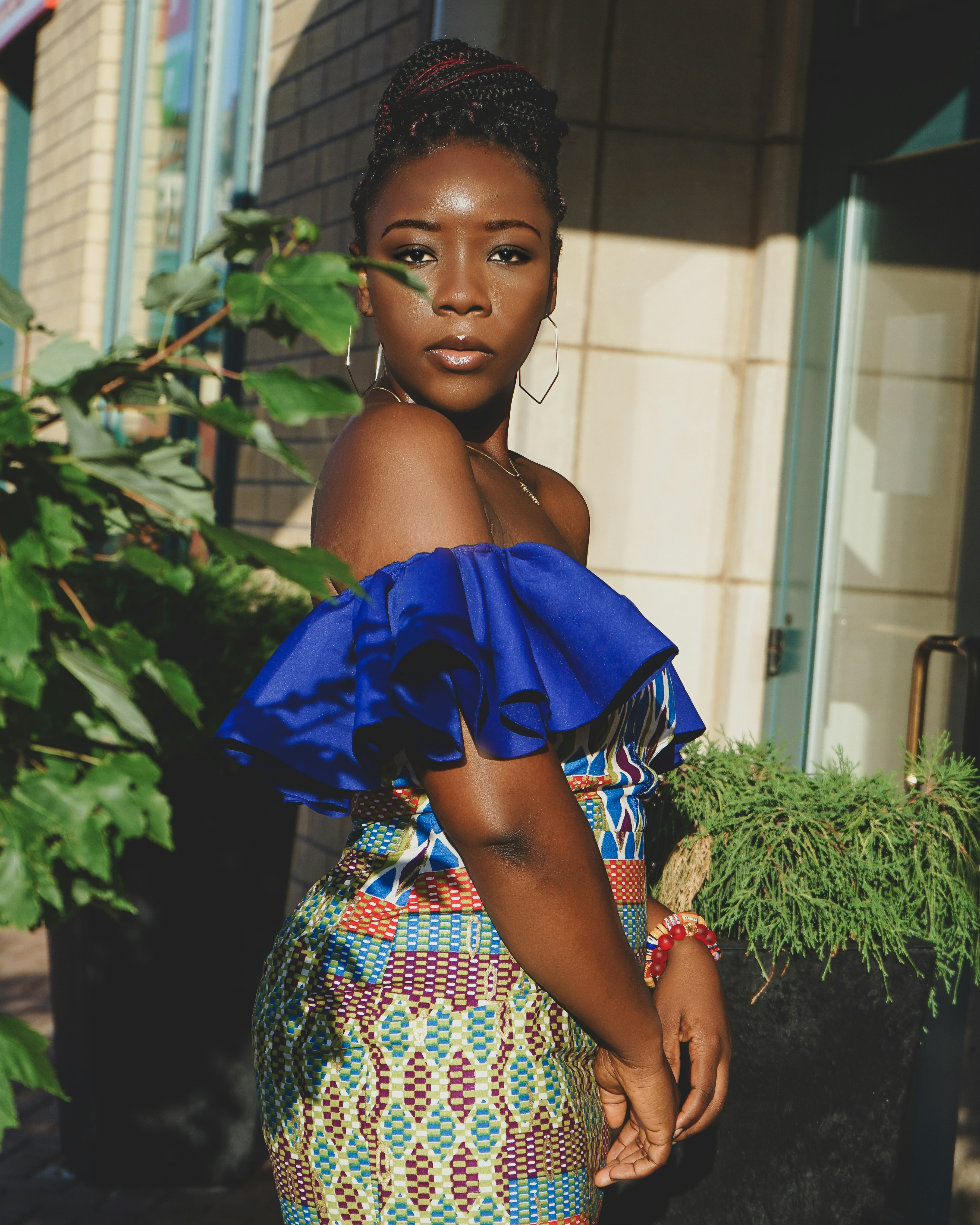 woman in blue red and white floral off shoulder dress holding blue umbrella