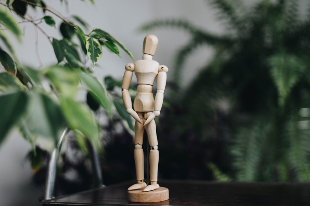 brown wooden human figure on brown wooden table