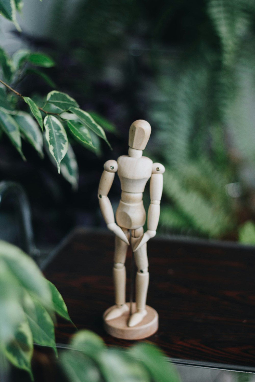 brown wooden human figure on brown wooden table