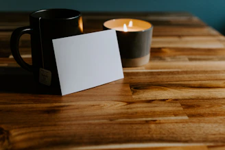 A cozy handwritten letter resting beside a steaming cup of tea on a wooden table.