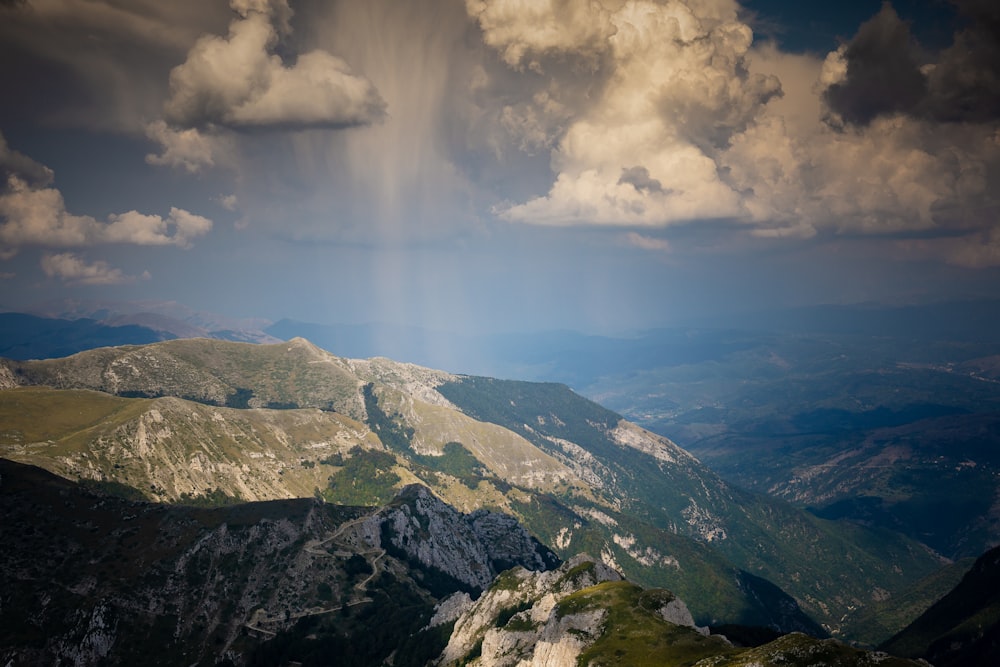 green and gray mountain under white clouds and blue sky during daytime