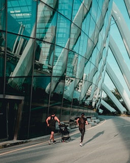 people walking on sidewalk near glass building during daytime