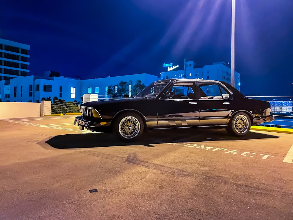 black sedan on parking lot during night time