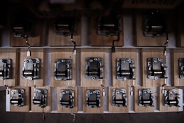 An elegant collection of various music boxes displayed on a rustic wooden shelf.
