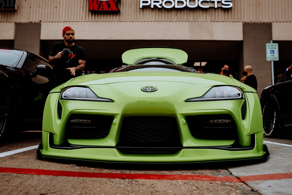 green lamborghini aventador in front of people