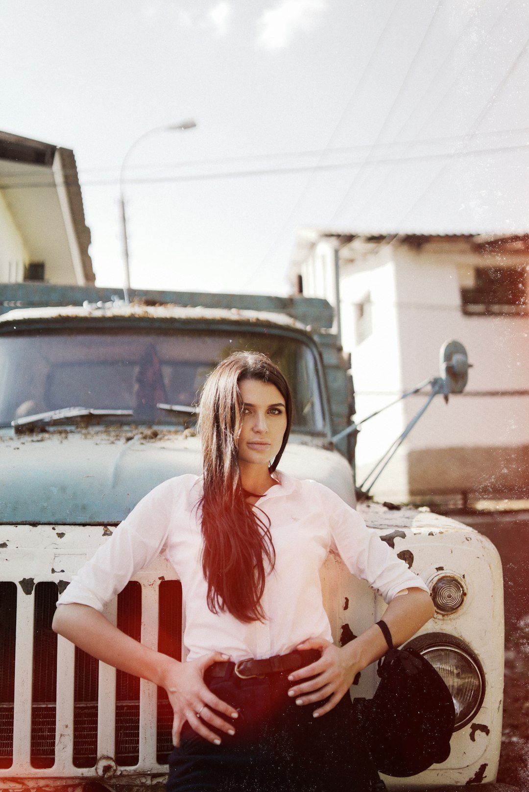 woman in white and red crew neck t-shirt sitting on white truck during daytime