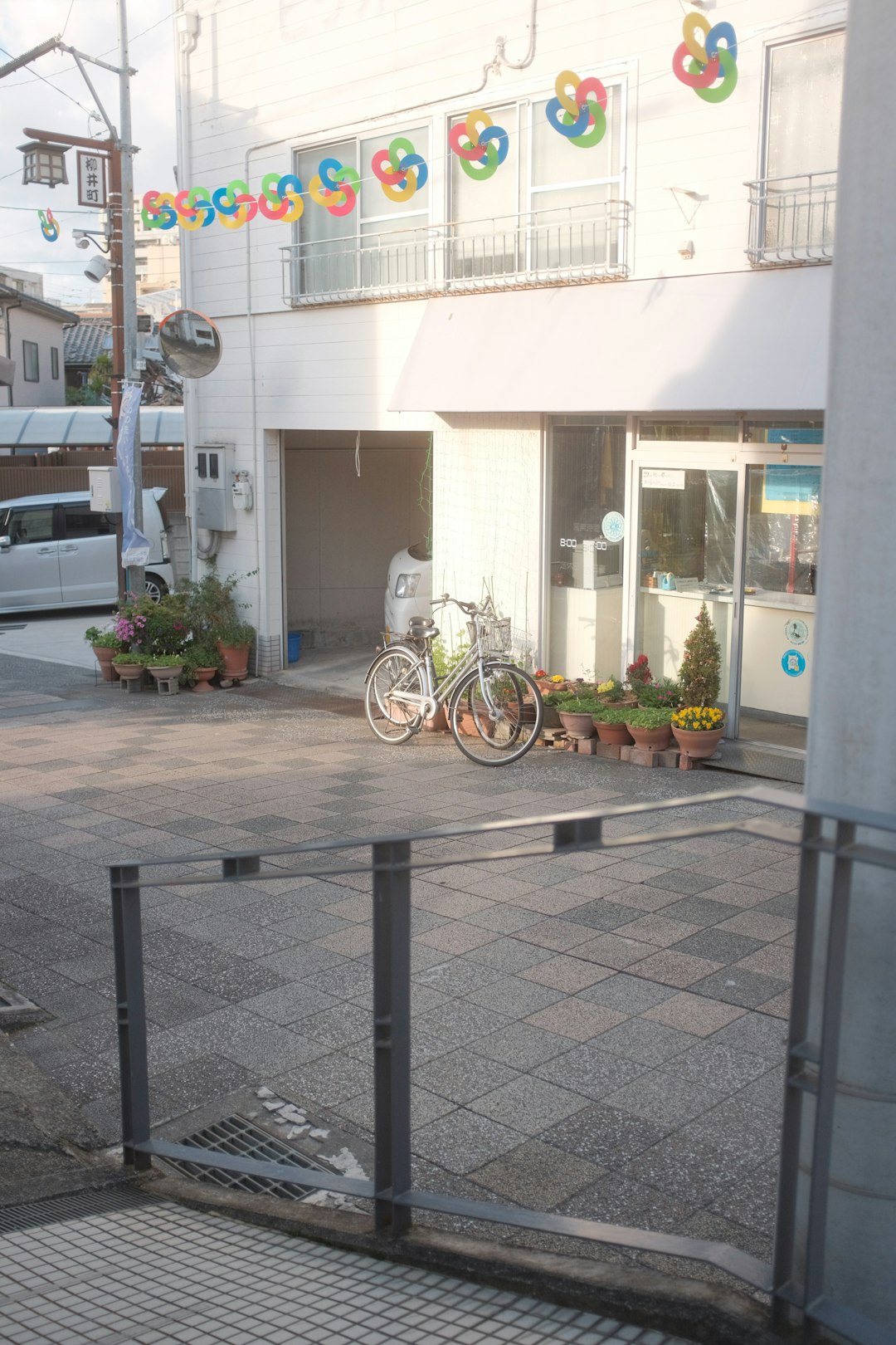 white bicycle parked beside black metal fence