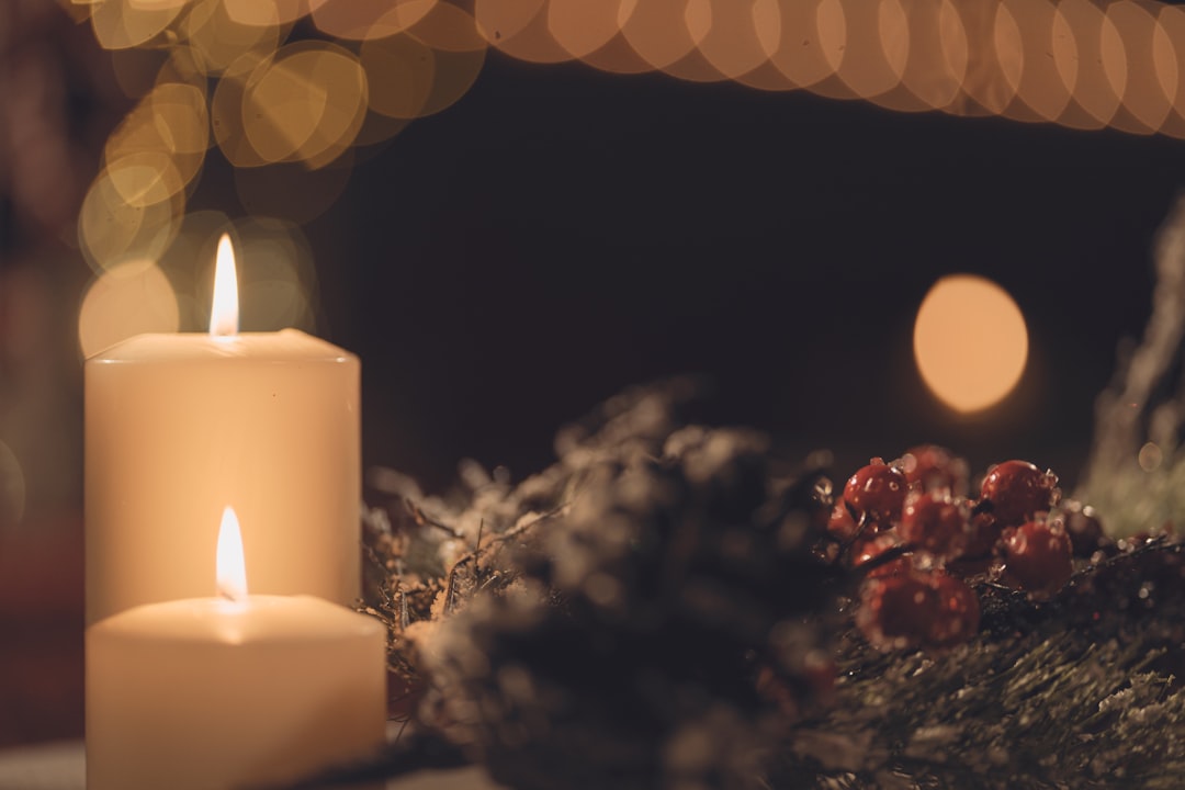 white pillar candle on brown wooden table,