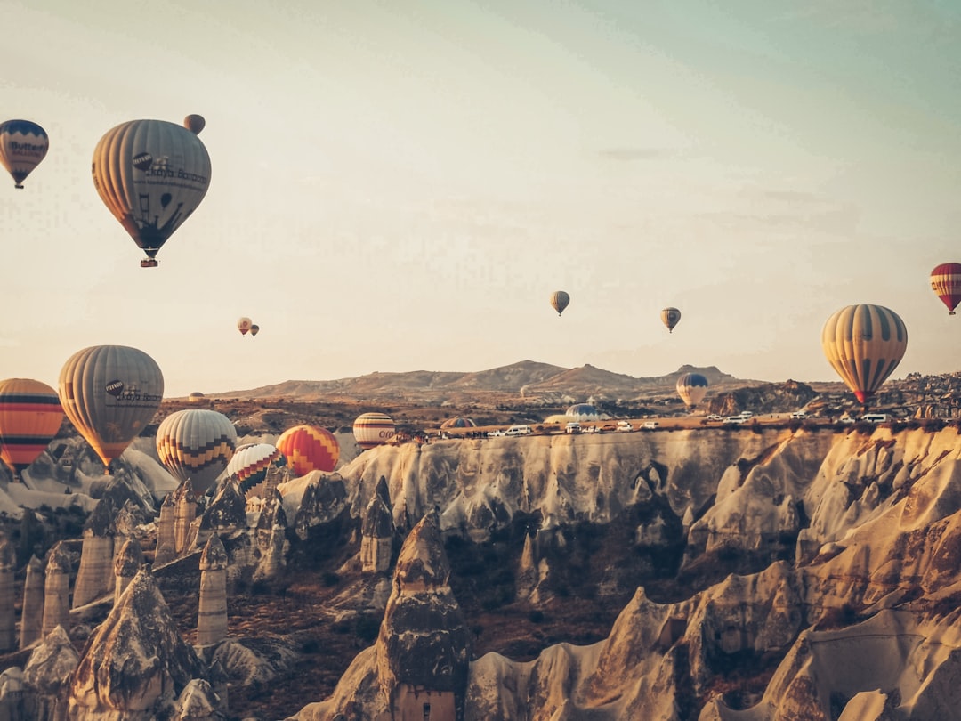 hot air balloons floating over rocky mountains during daytime