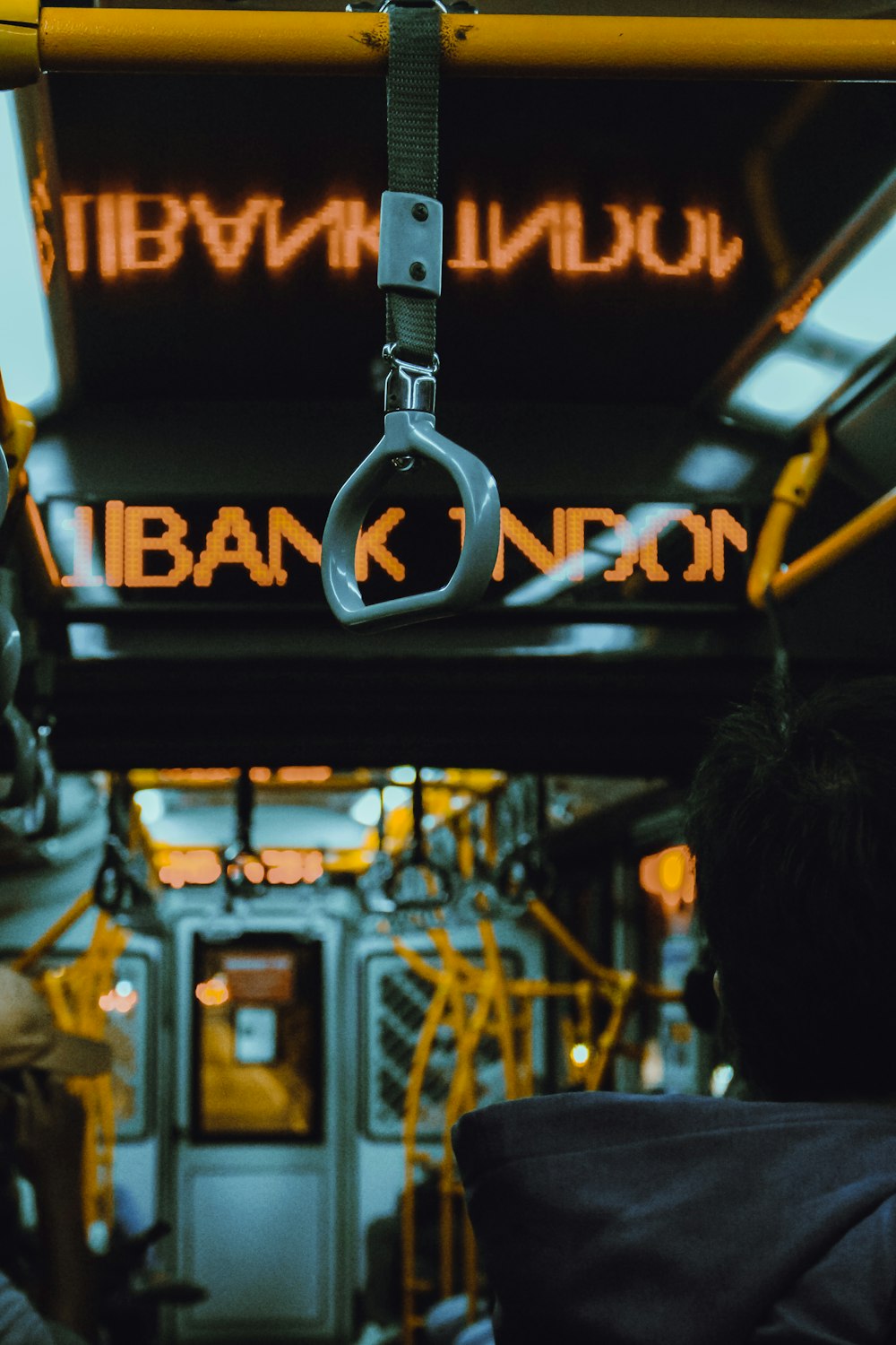 Una persona su un autobus con un'insegna al neon sullo sfondo