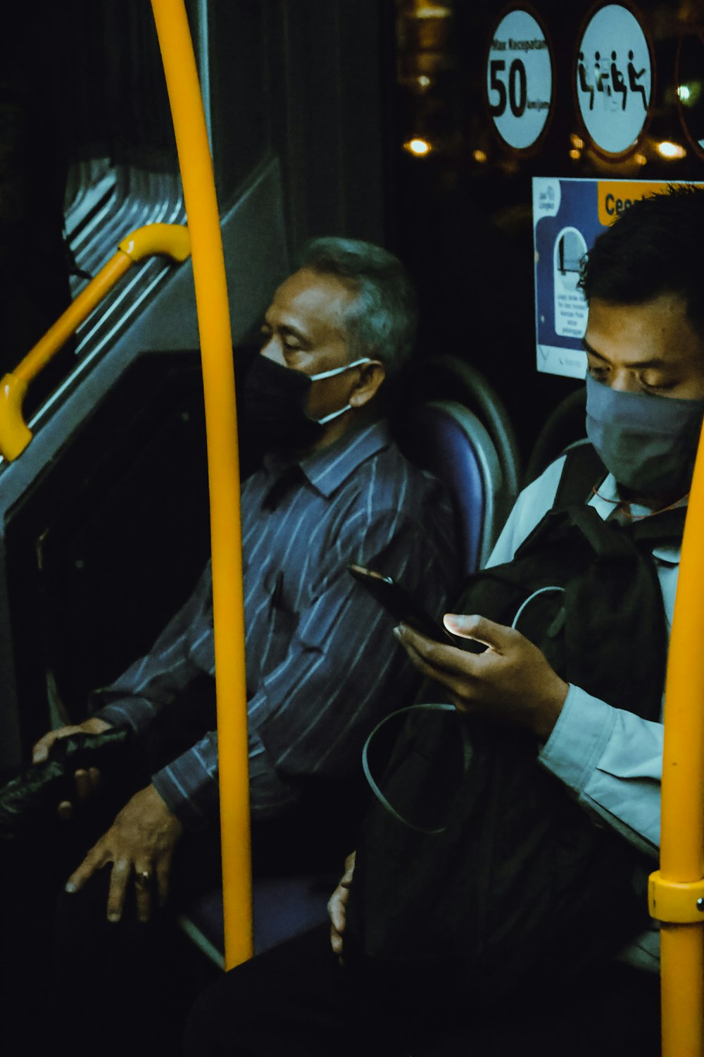 man in blue jacket holding smartphone