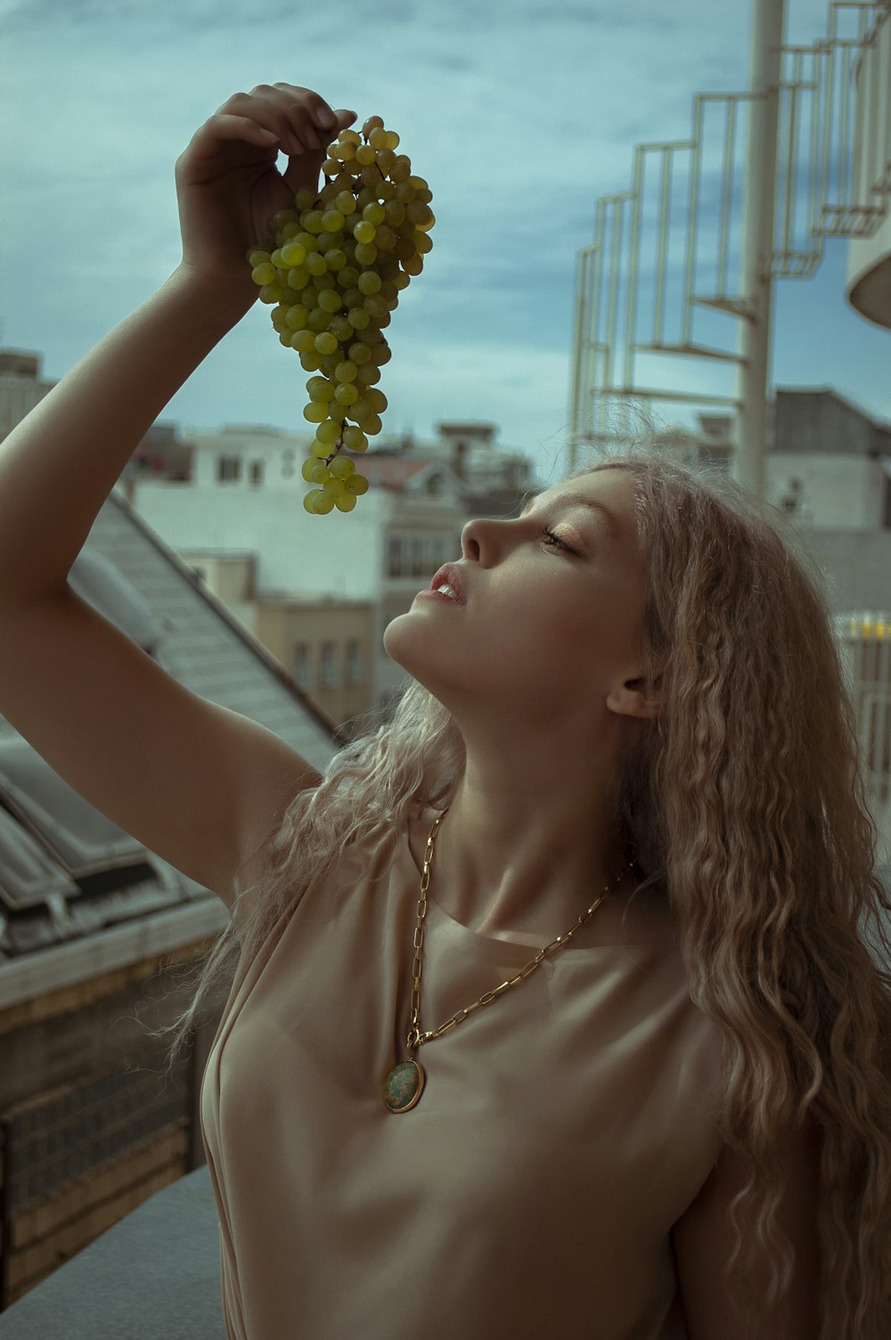 woman in white tank top holding yellow flower