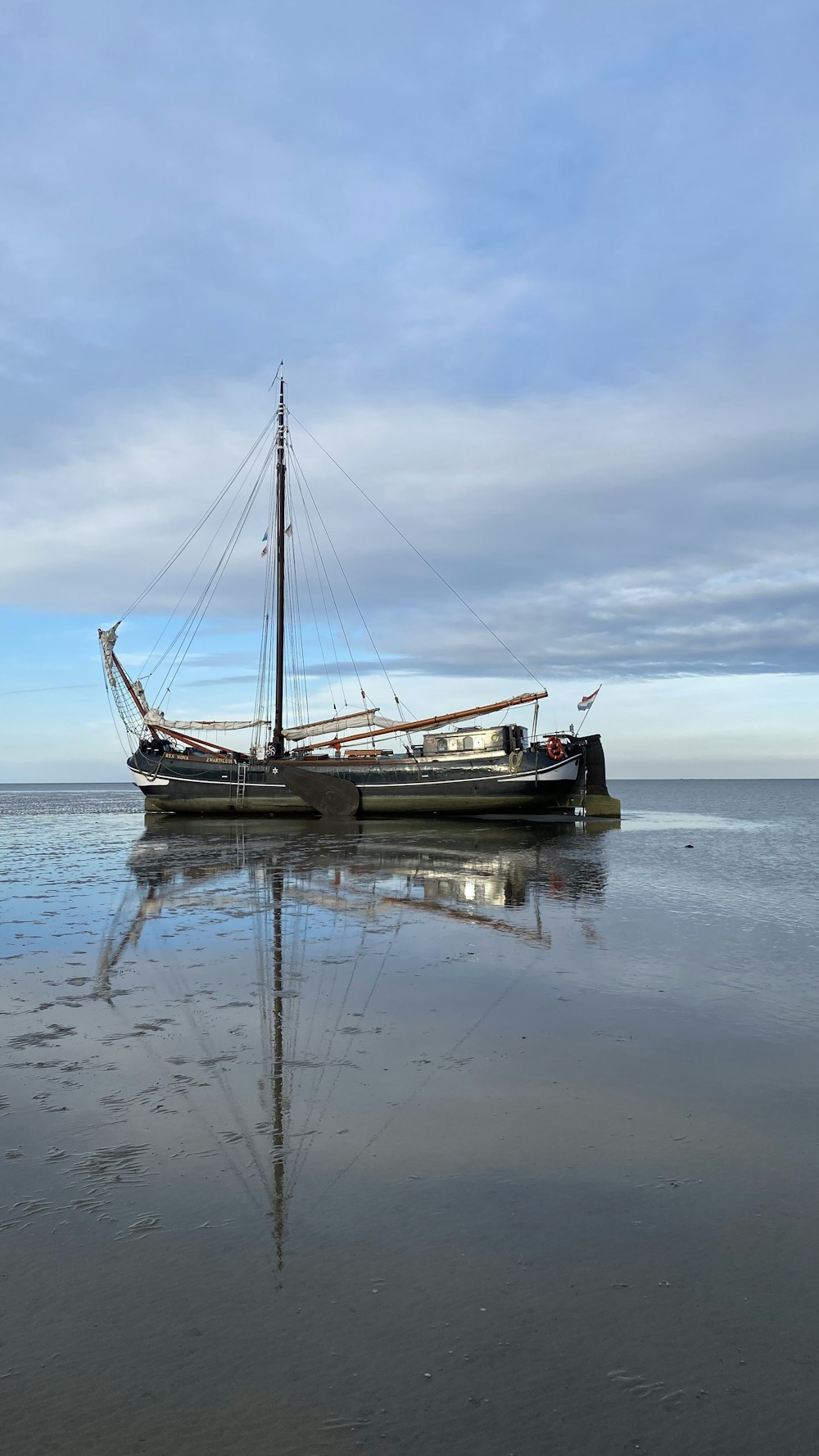 white and brown boat on sea under white clouds during daytime