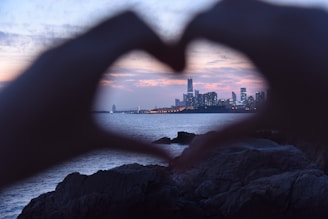 Close-up of hands shaking in agreement with Nairobi’s skyline subtly in the background at dusk.