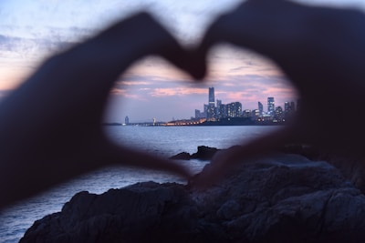 Close-up of hands shaking in agreement with Nairobi’s skyline subtly in the background at dusk.