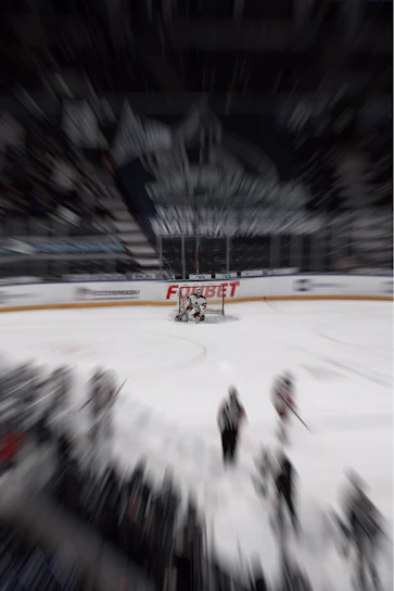 Action shot of a player gripping a hockey stick mid-swing on the ice, with motion blur emphasizing speed and power.