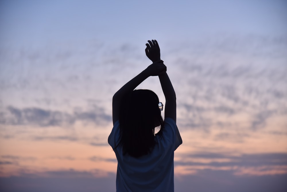 silhouette of woman covering her face with her hands