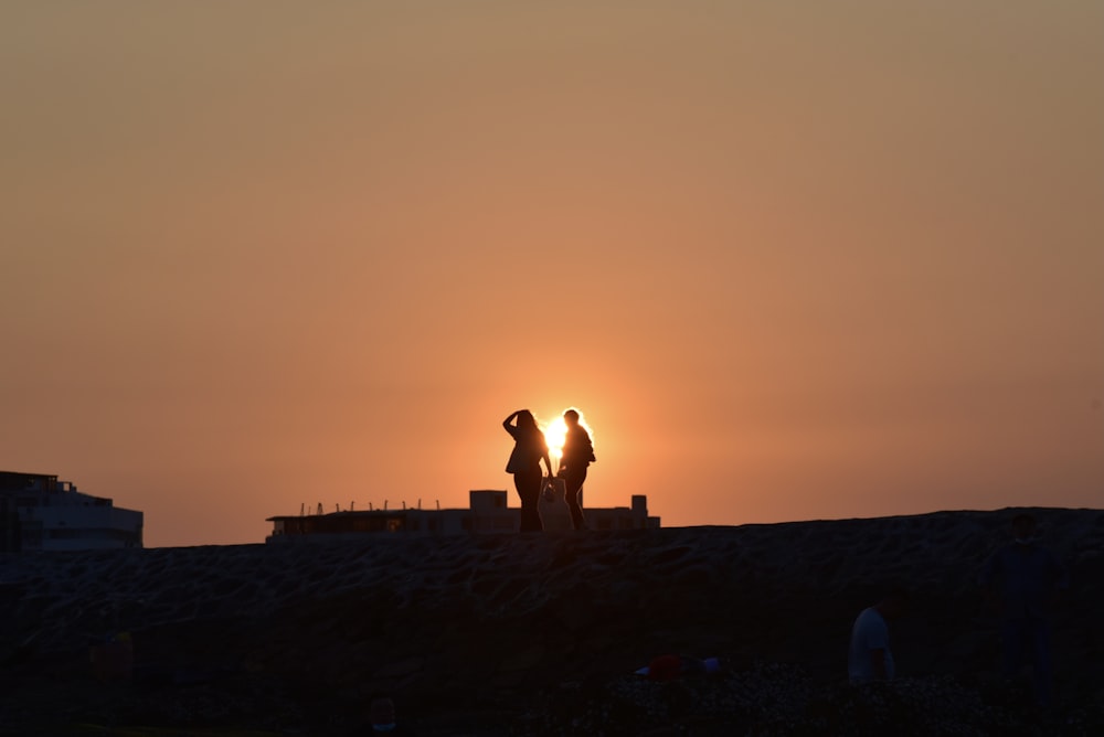 silhouette of people on beach during sunset