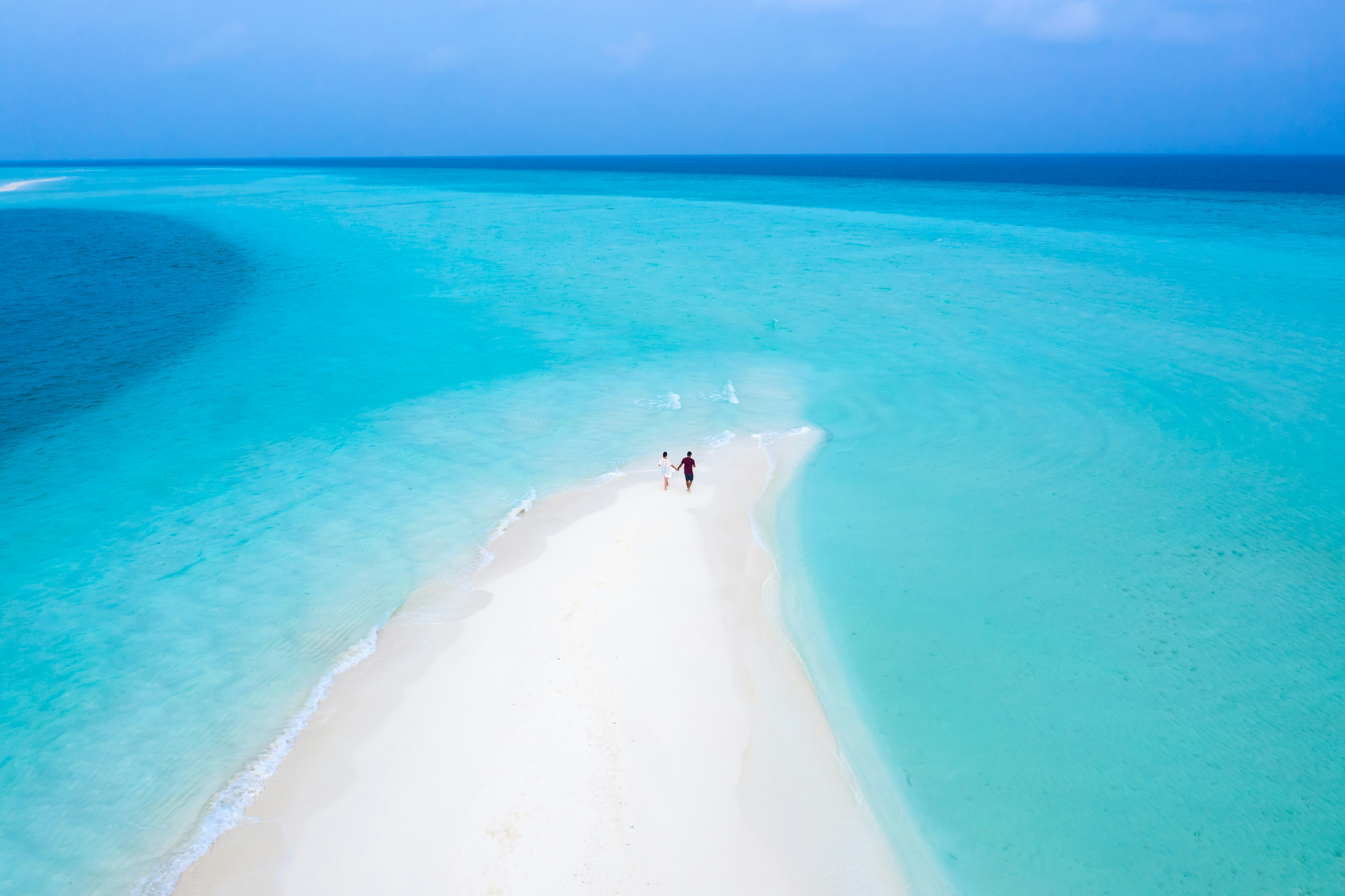 person in black shirt standing on white sand beach during daytime, Maldives - the perfect gateway. 