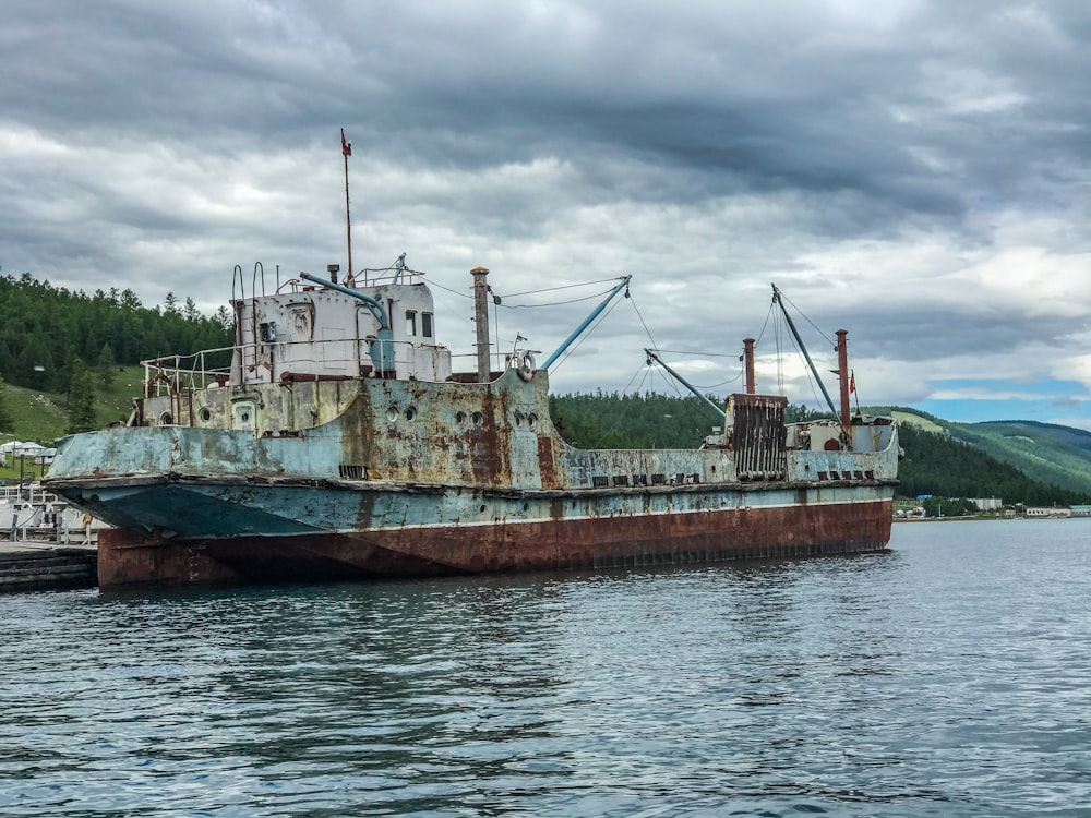 brown and white ship on sea under white clouds during daytime