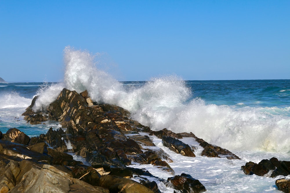 ocean waves crashing on rocks during daytime