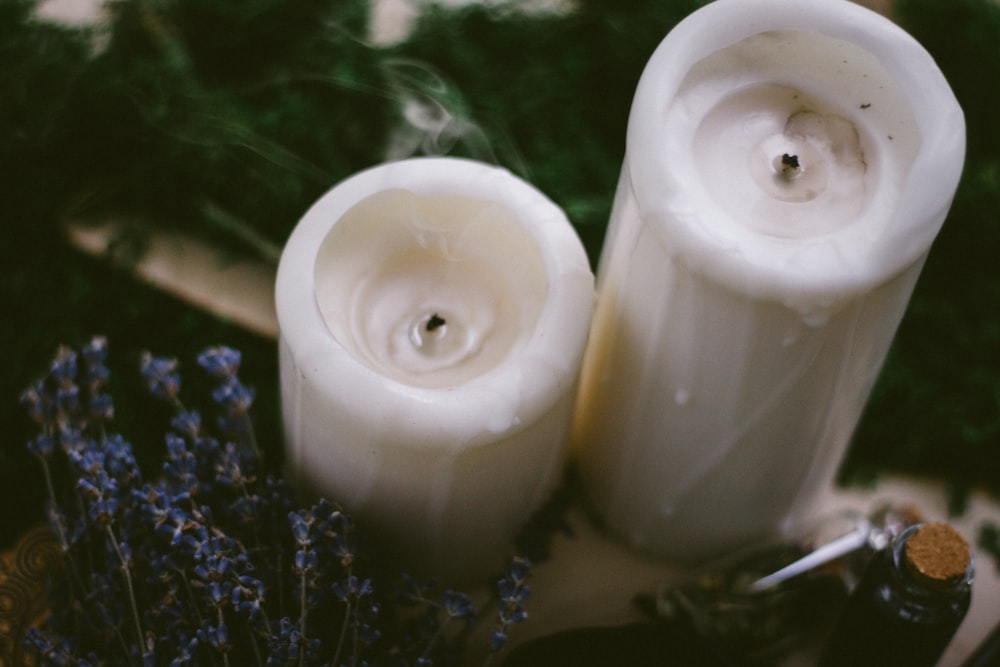 2 white pillar candles on water