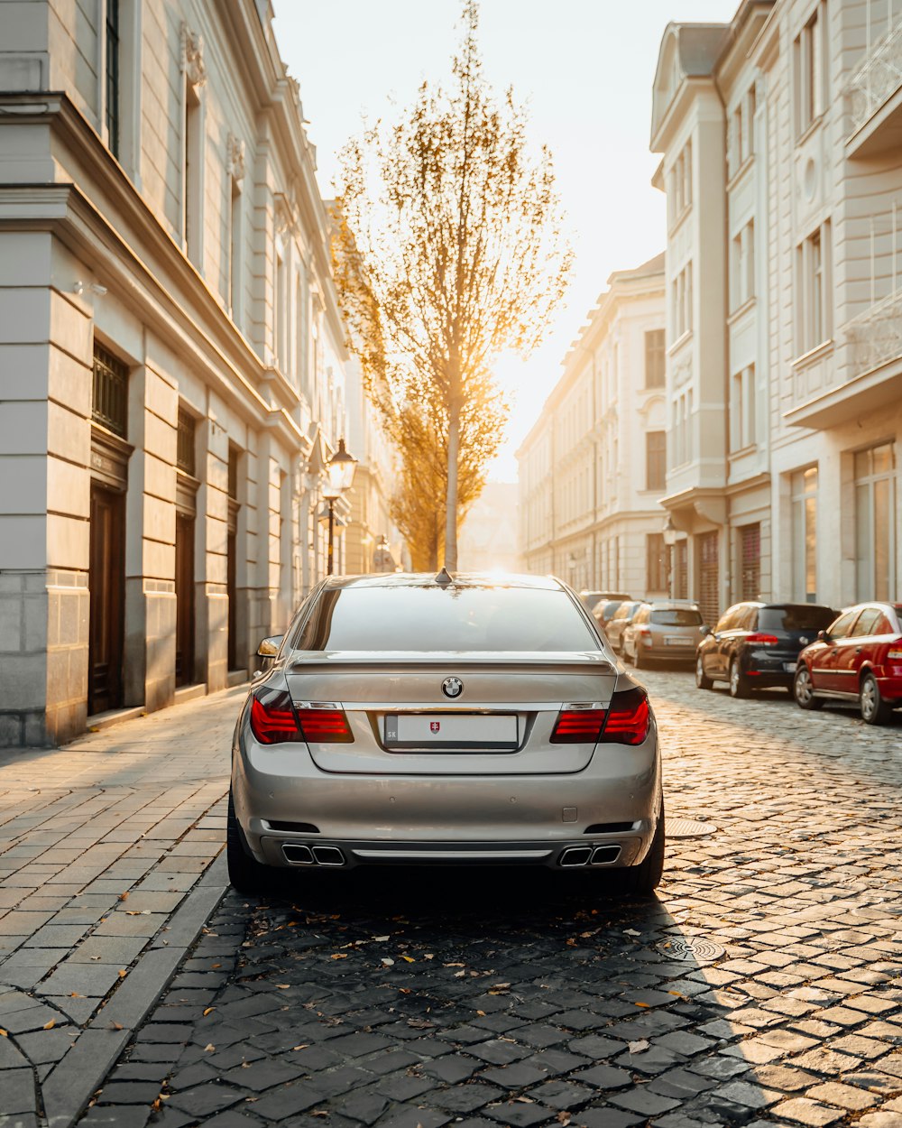 a silver car parked on a cobblestone street