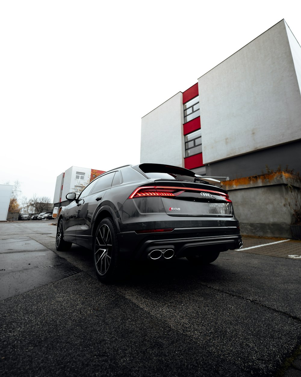 black car parked beside white wall