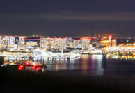 A night cityscape illuminated by colorful digital effects and reflections.