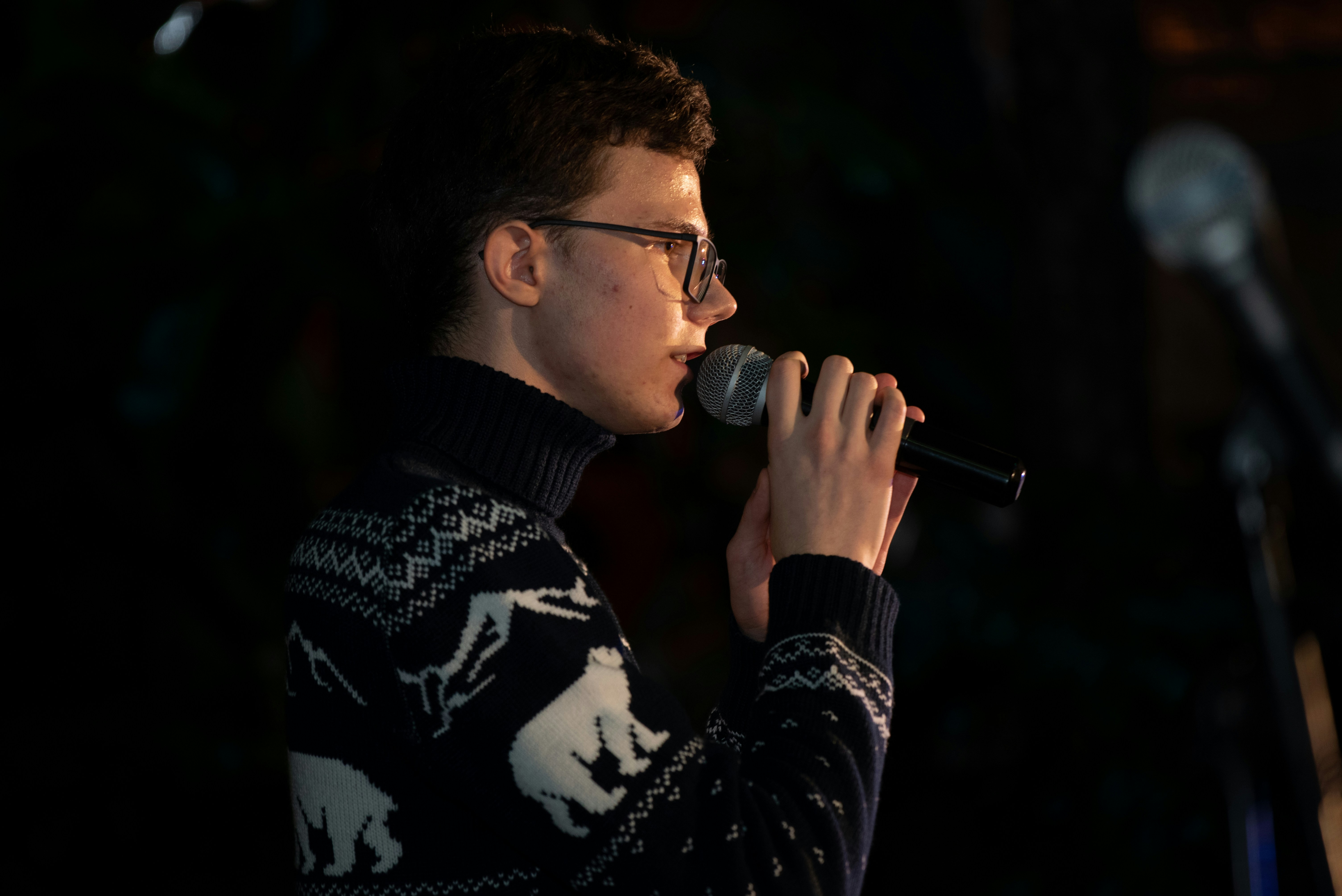 man in black and white long sleeve shirt holding microphone