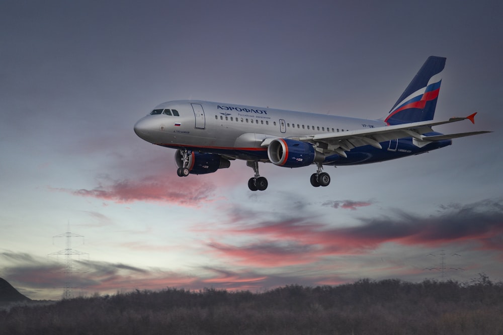 white and blue passenger plane in flight