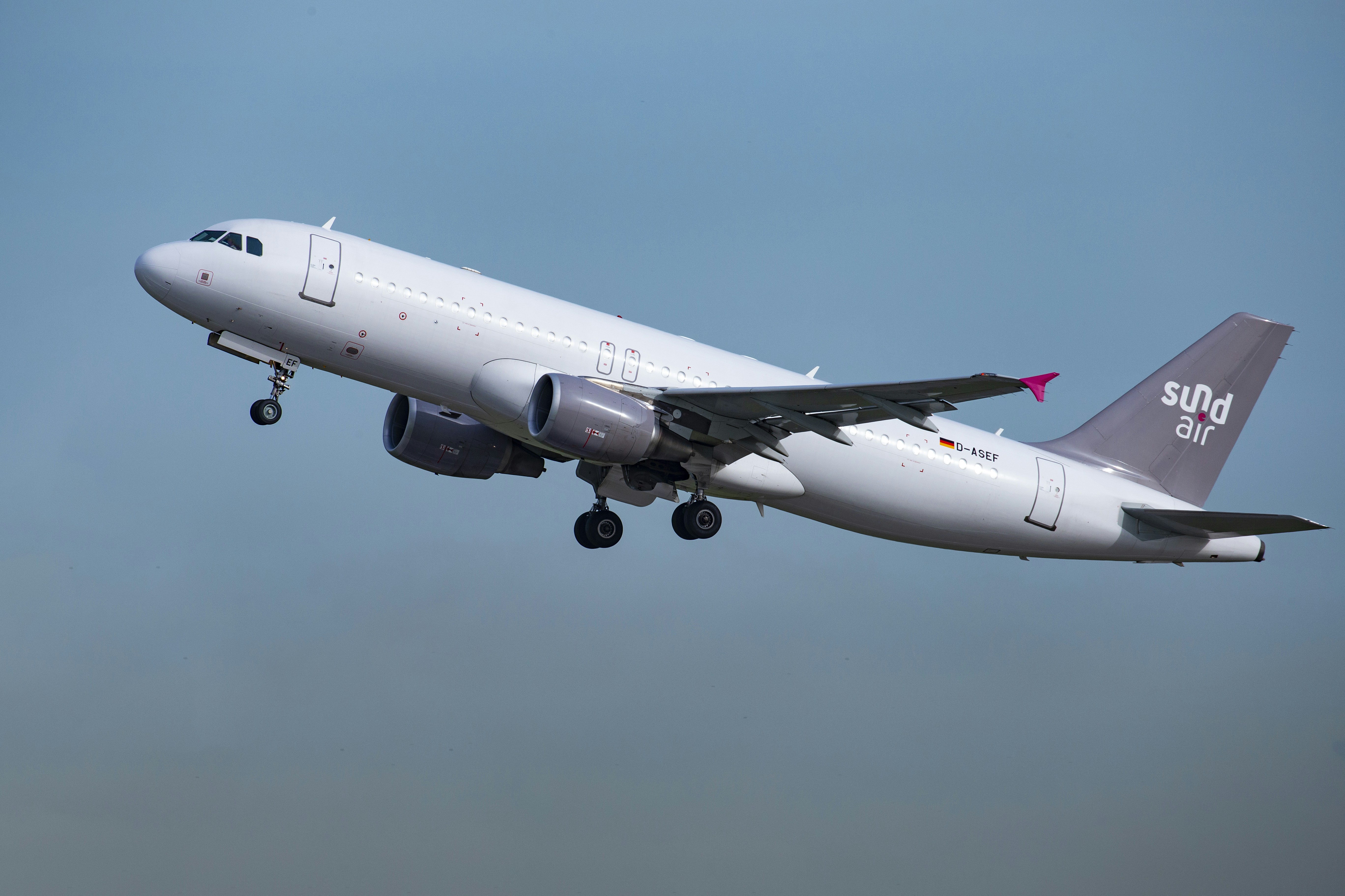 white passenger plane in mid air during daytime