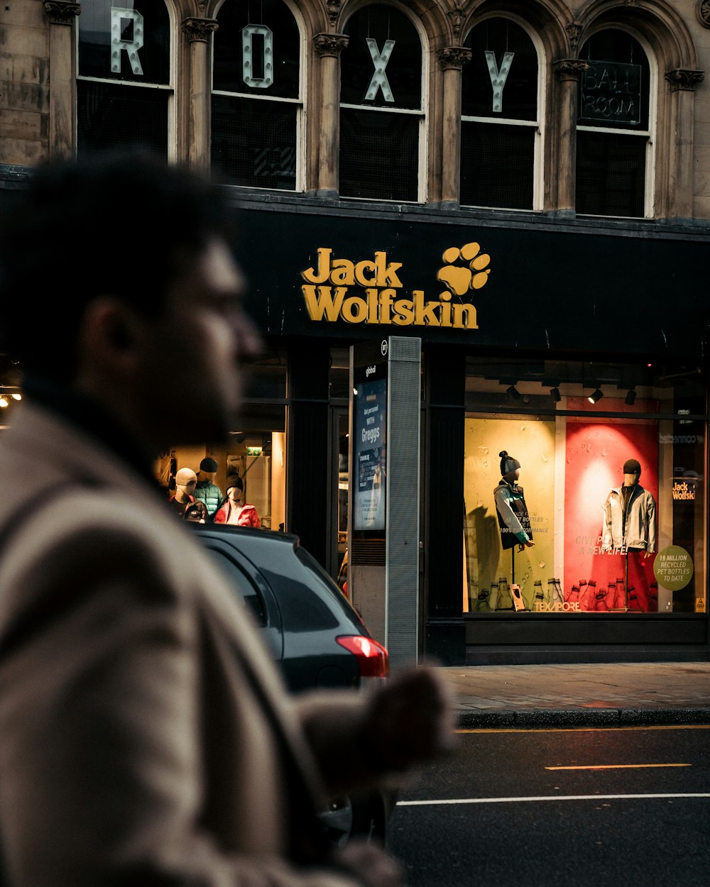 man in black coat standing near store