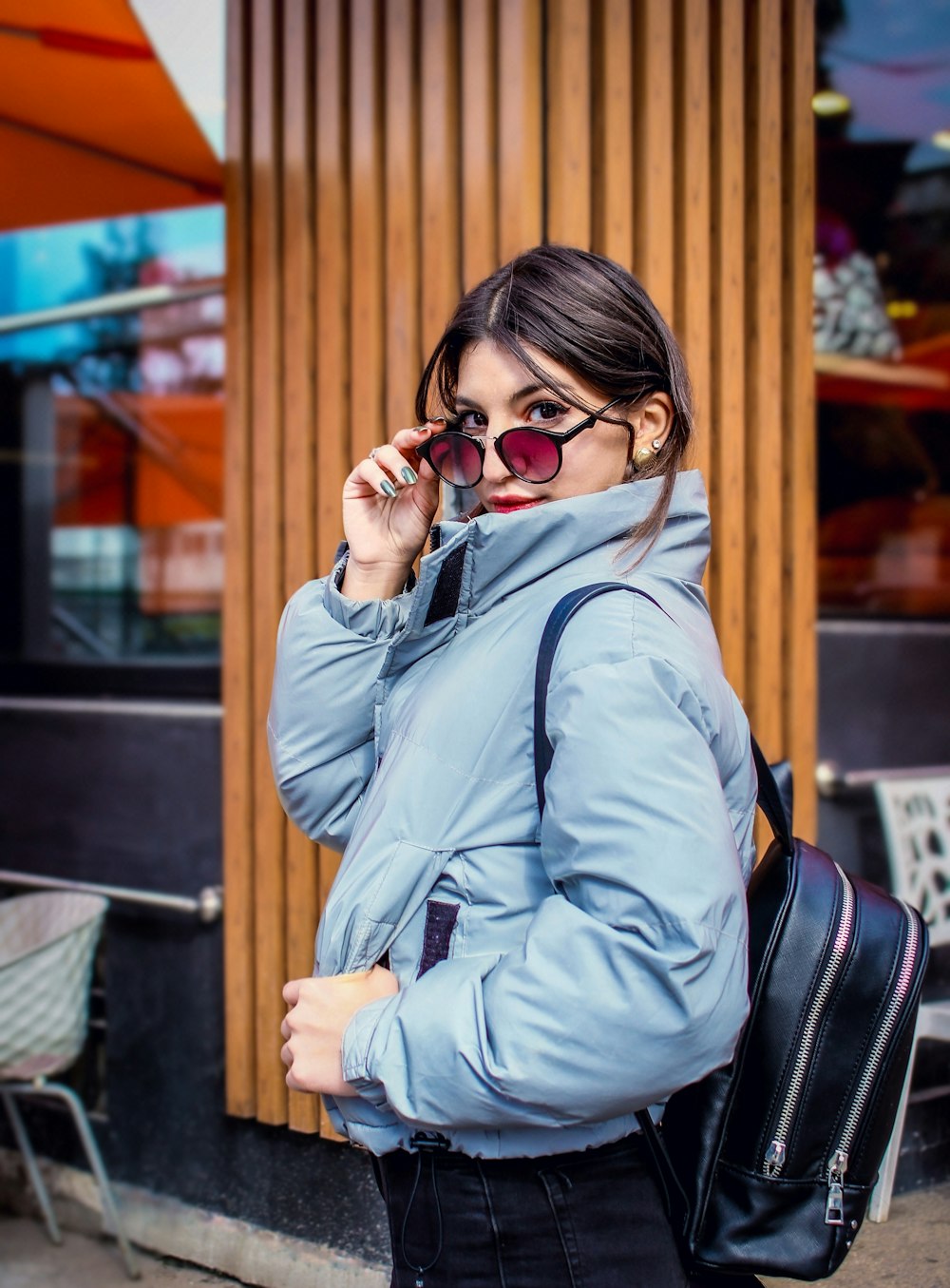 woman in blue jacket wearing black sunglasses