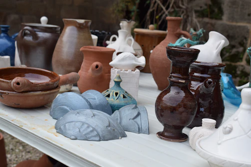 Close-up of vintage pottery pieces arranged neatly on a weathered wooden table.