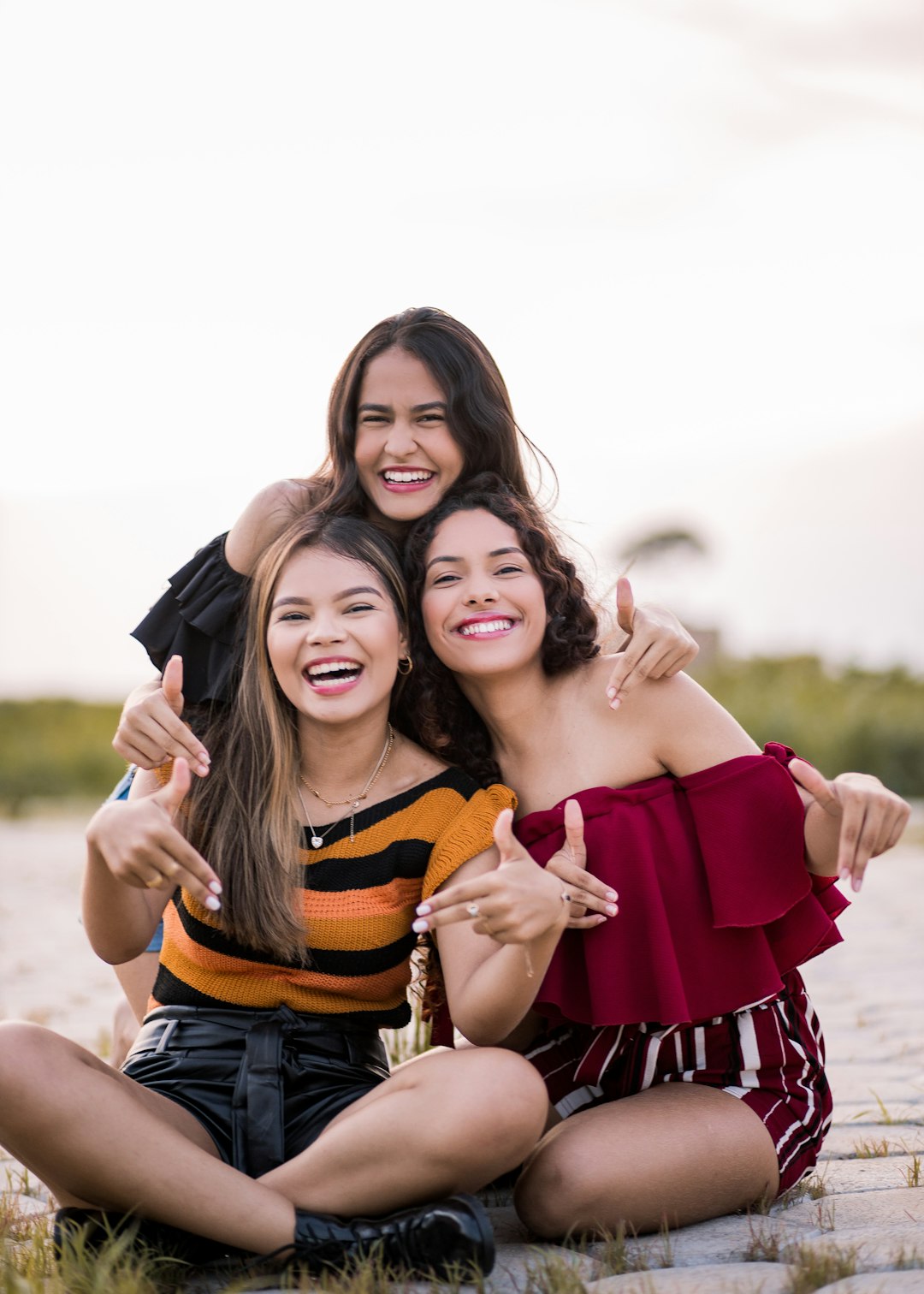 2 women smiling and standing on field during daytime