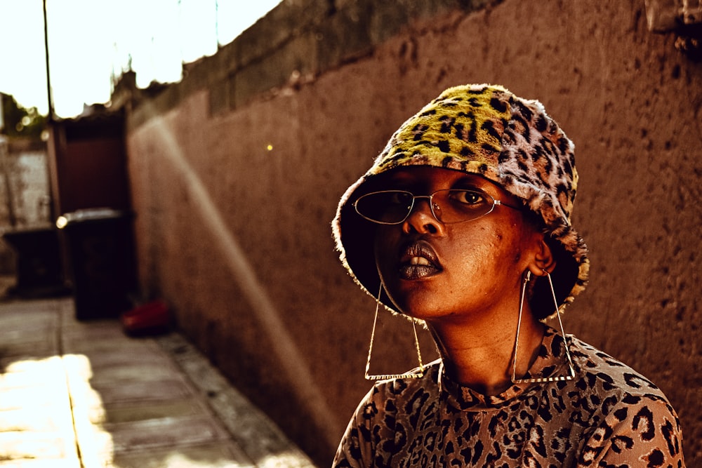 woman in brown and black leopard print shirt wearing sunglasses and white earbuds