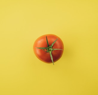orange tomato on yellow surface