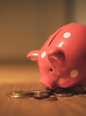 pink pig coin bank on brown wooden table