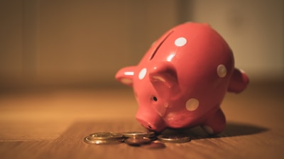 pink pig coin bank on brown wooden table