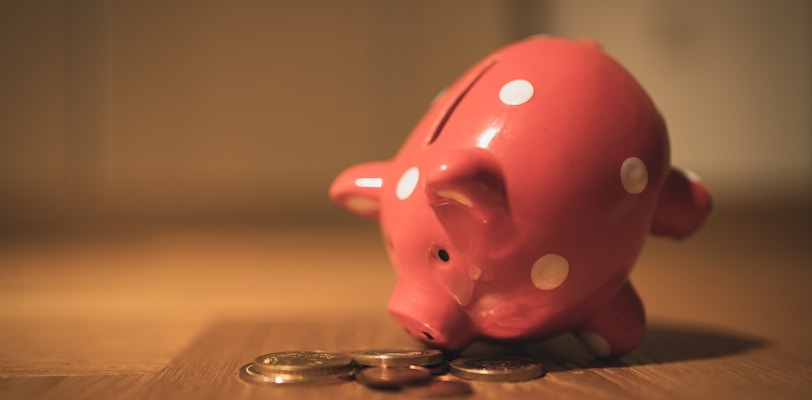 pink pig coin bank on brown wooden table