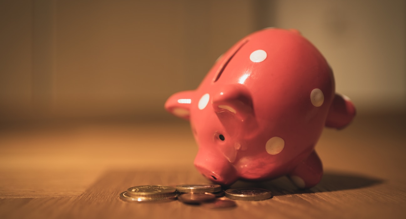 pink pig coin bank on brown wooden table