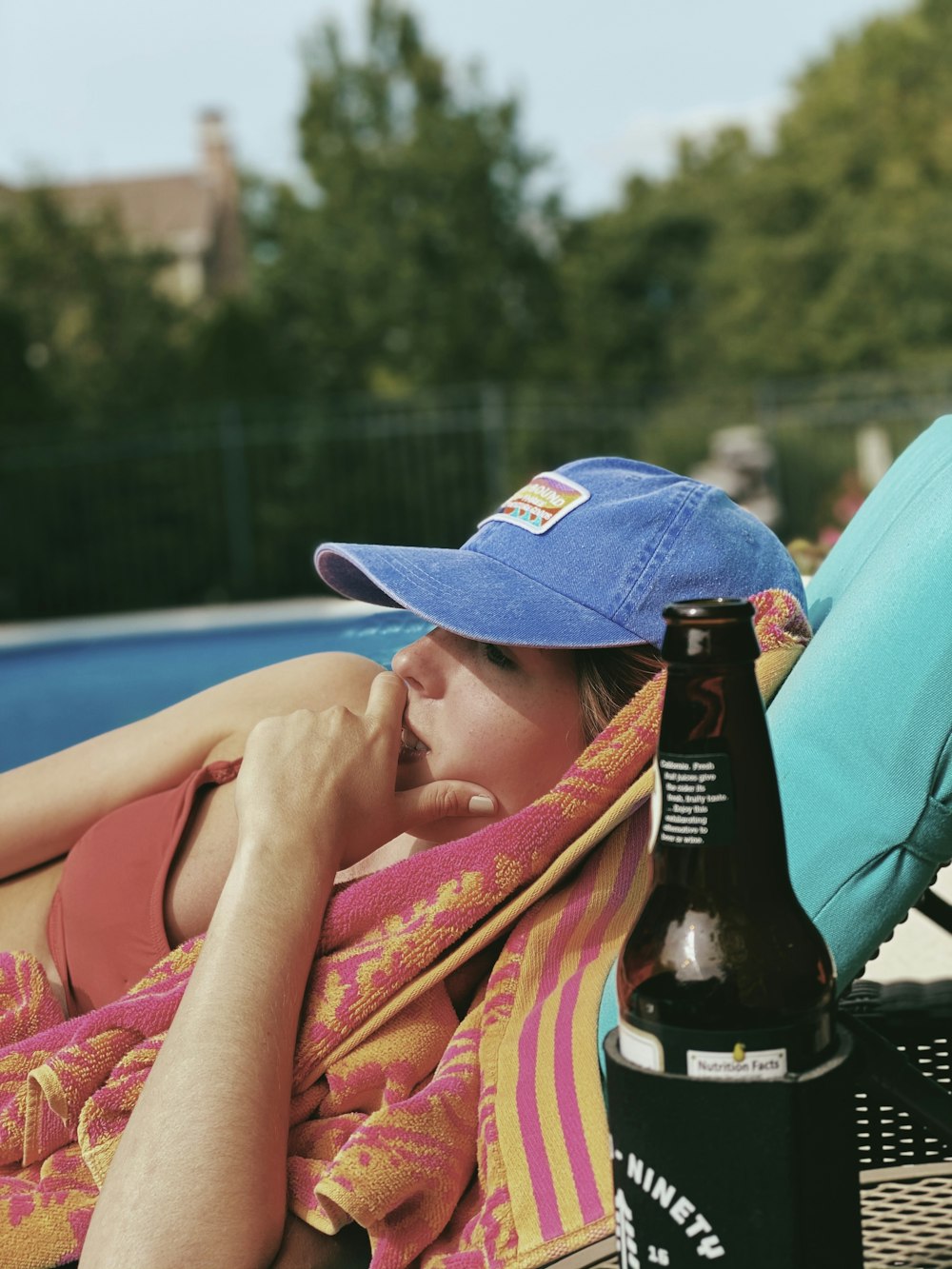 Frau mit blauem Hut liegt auf blauem Textil