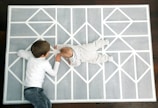 Children playing on colorful interlocking mats in a playroom.