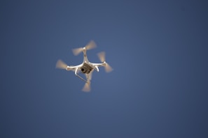 A drone in flight against a clear blue sky, showcasing its performance.