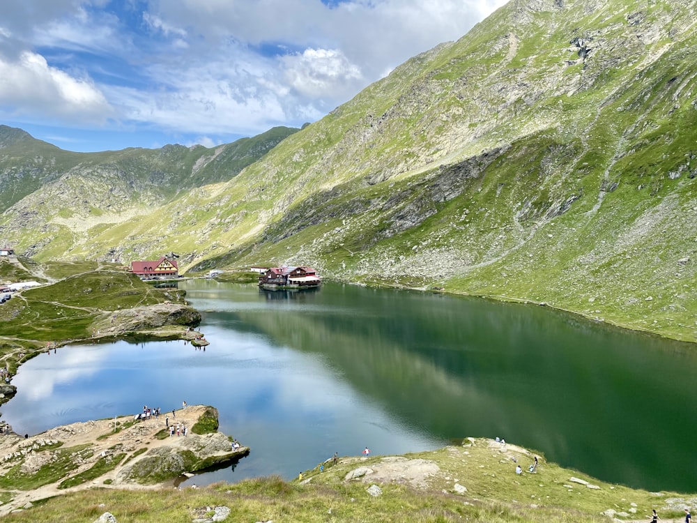 green mountains beside lake under blue sky during daytime