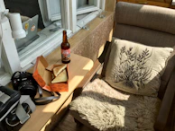 Cozy corner in room with plush pillows and a vintage film camera on the table.