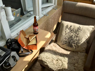 Cozy corner in room with plush pillows and a vintage film camera on the table.